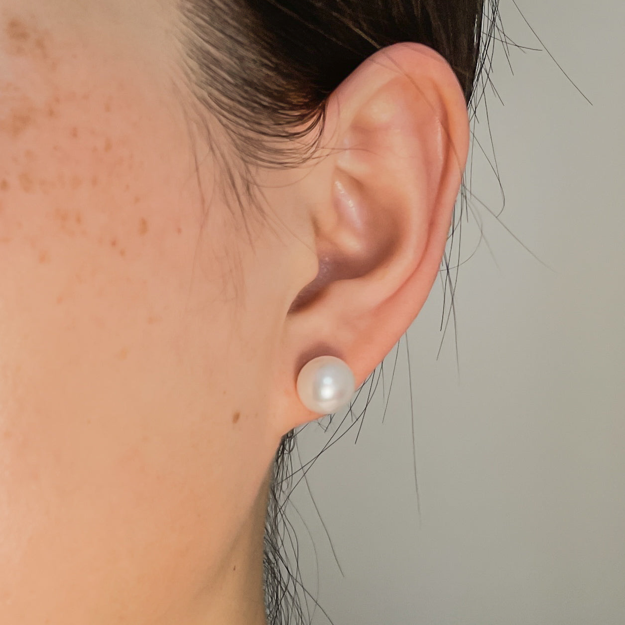 button shape pearl earrings on ear