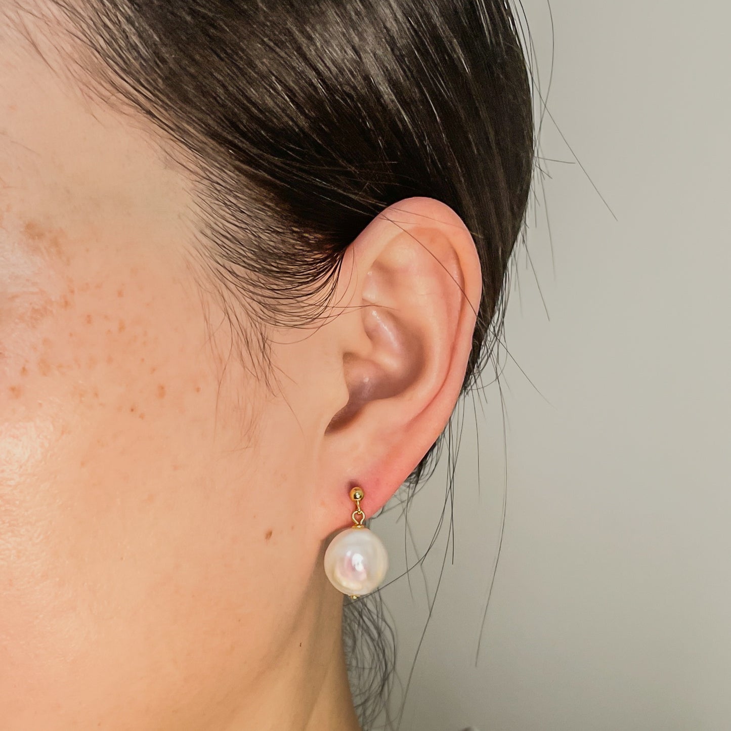 coin pearl earrings on ear
