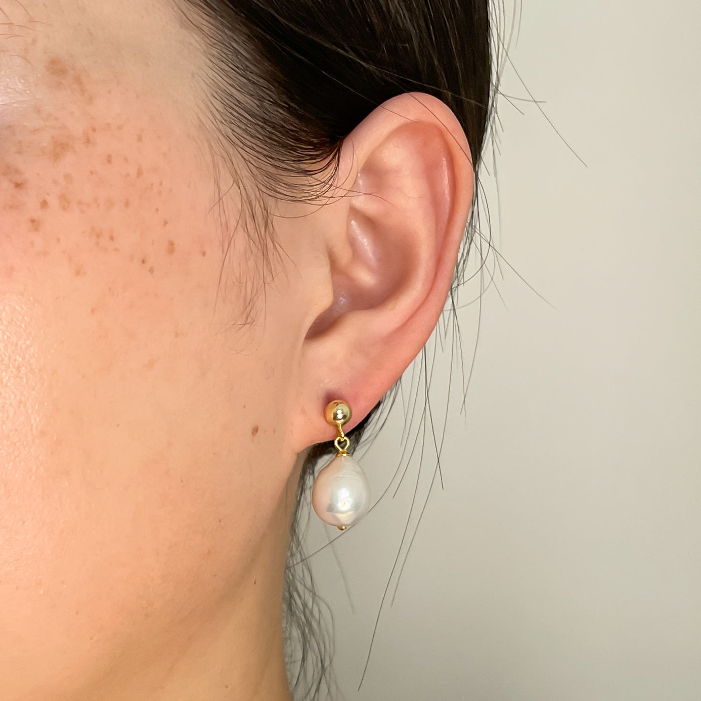 snowman earrings on ear